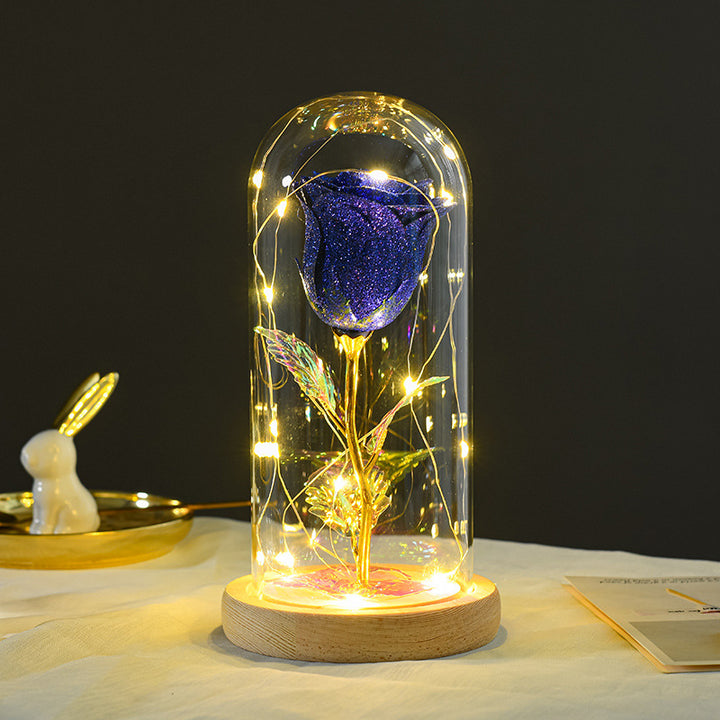 Rode eeuwige roos in glazen stolp met lichtjes