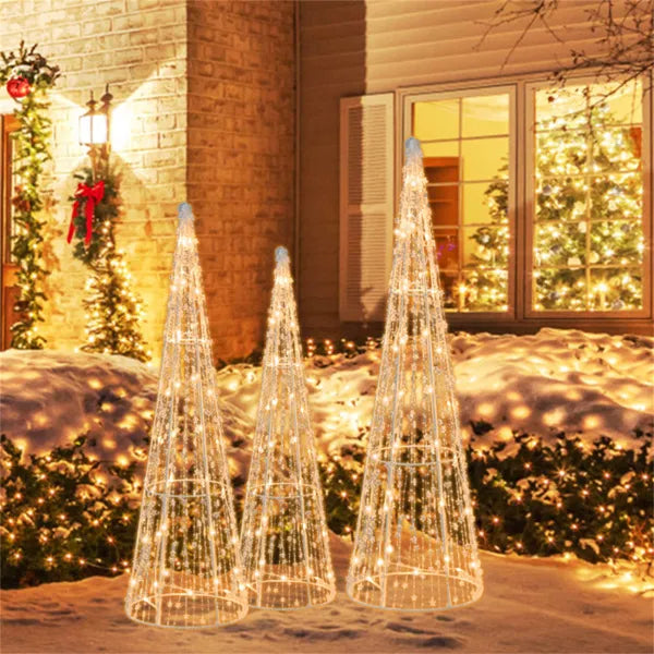 Drie verlichte kegelkerstbomen in de tuin