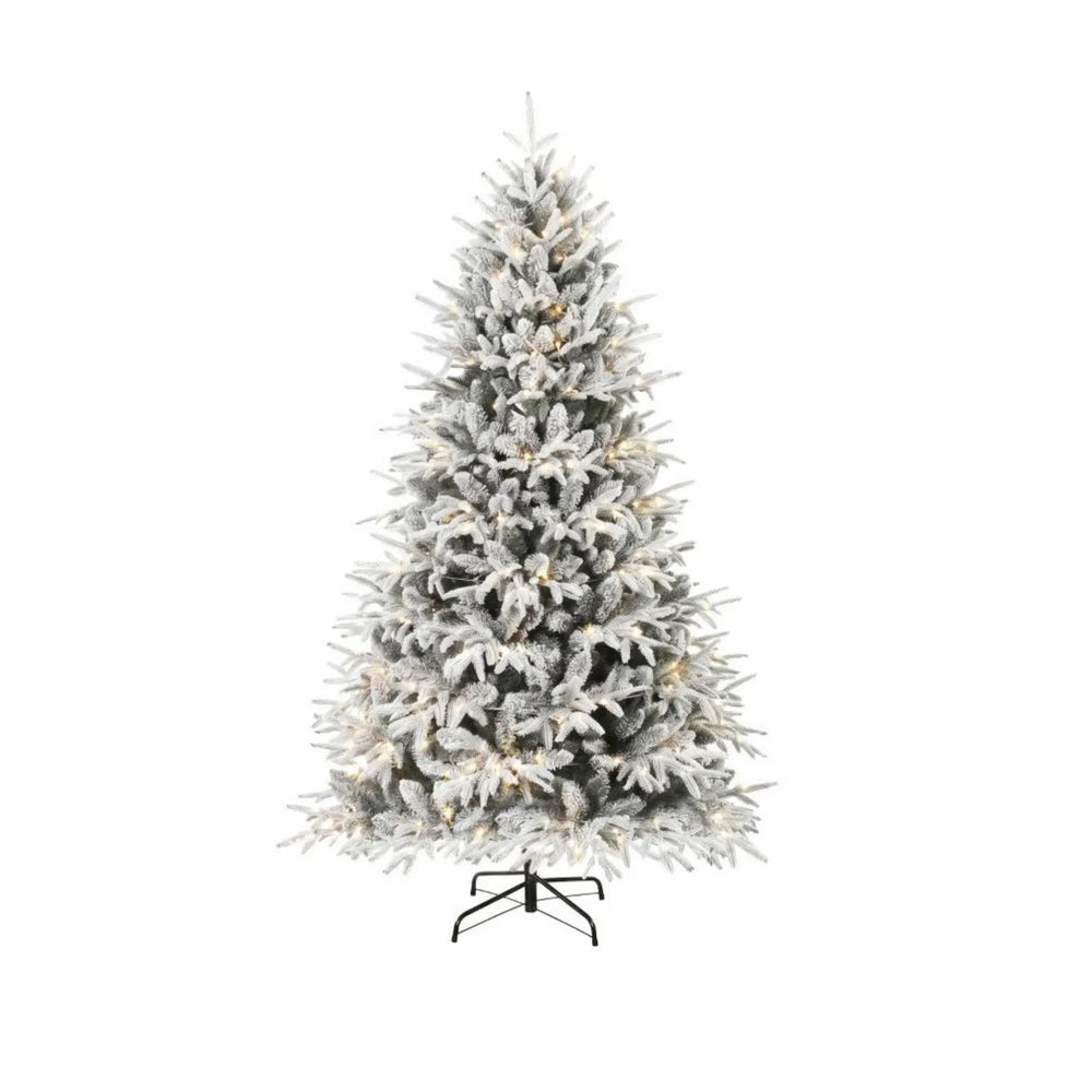 Volle besneeuwde kerstboom met warm licht