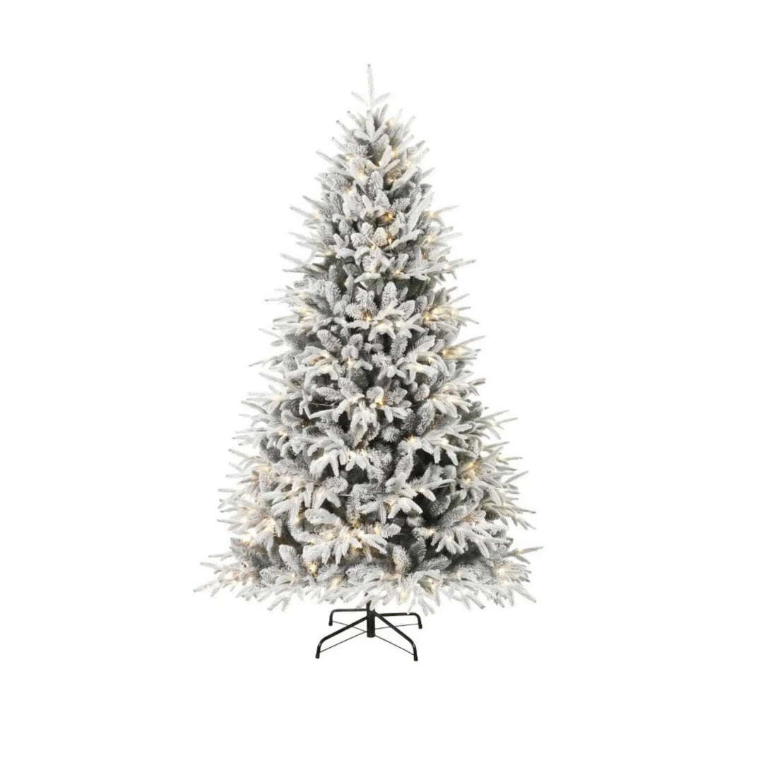 Volle besneeuwde kerstboom met warm licht