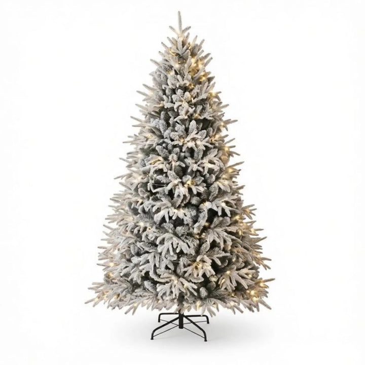 Extra volle besneeuwde kerstboom met lichtjes