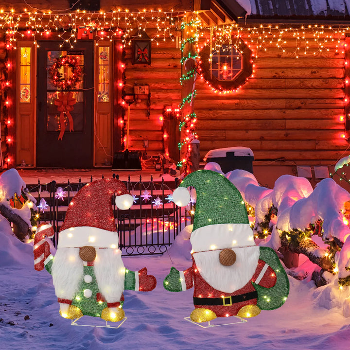 Twee verlichte kerstkabouters in de tuin