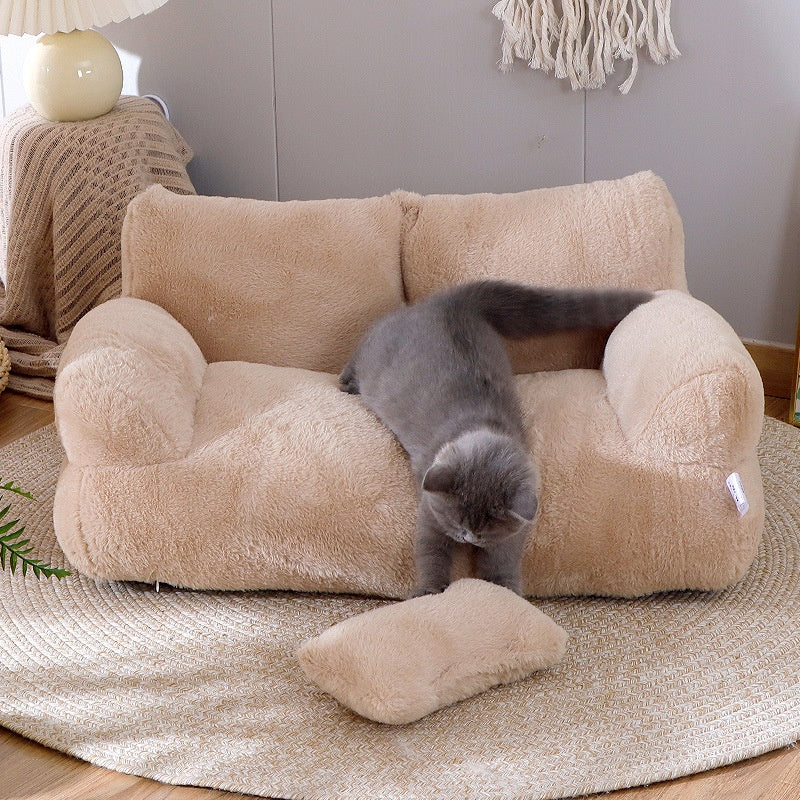 Kat ligt op een crèmekleurige pluche kattenbank