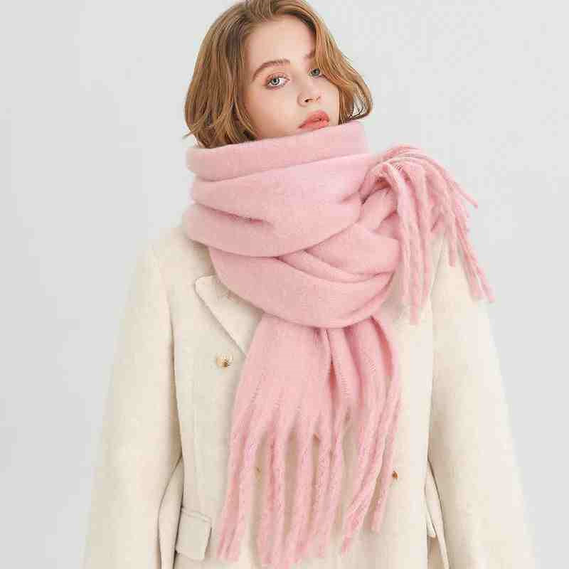 Vrouw met dikke wintersjaal met kwasten
