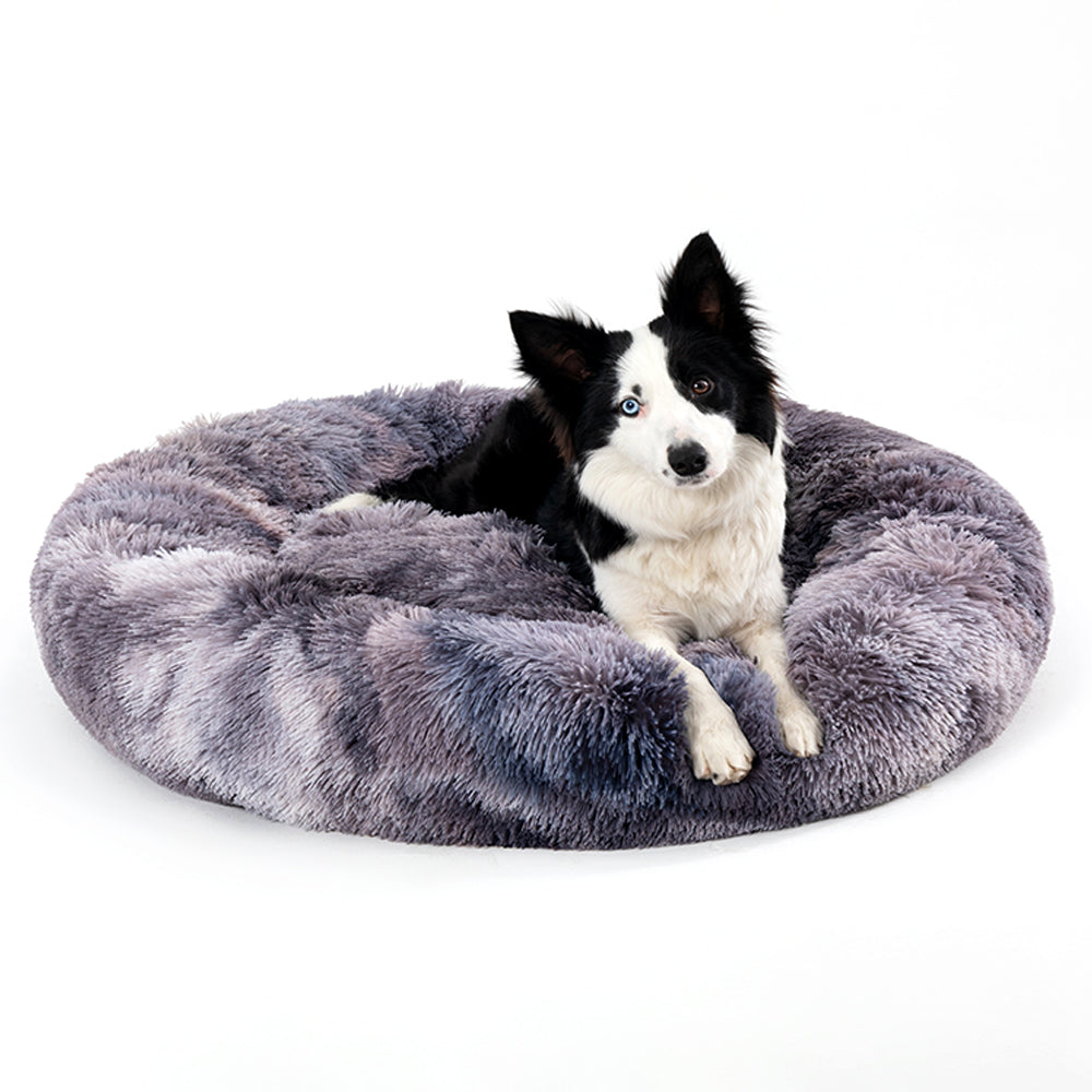 Hond ligt opgerold in een grijze donutmand