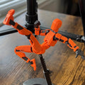 Oranje 3D-geprinte robotfiguur in actiehouding