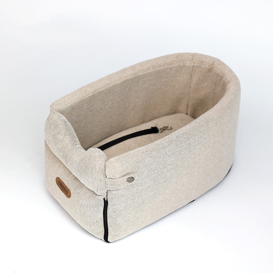 Kleine hond in een beige autostoeltje op de armleuning