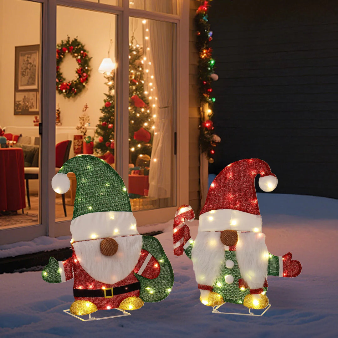 Twee verlichte kerstkabouters in de tuin