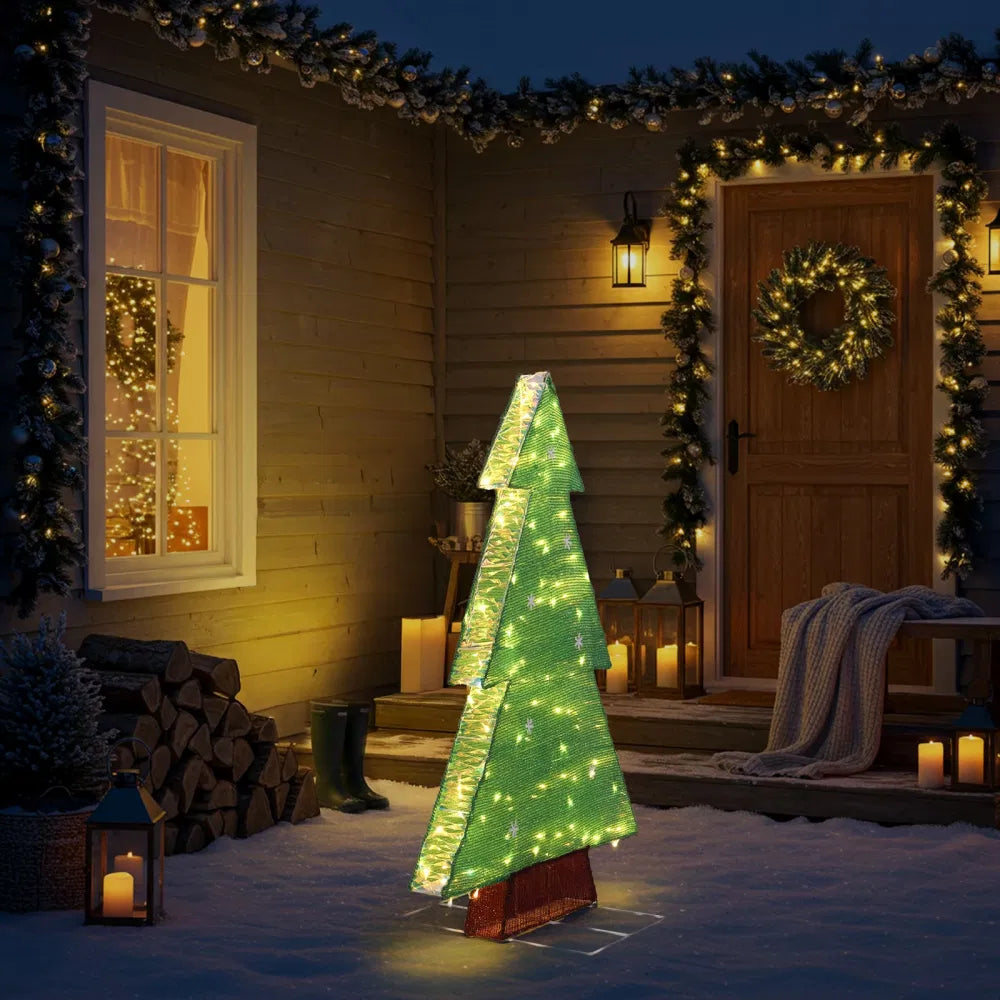 Verlichte kerstboom met sneeuwvlokken buiten