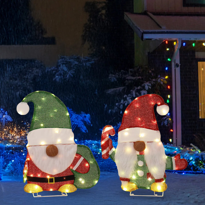 Twee verlichte kerstkabouters in de tuin