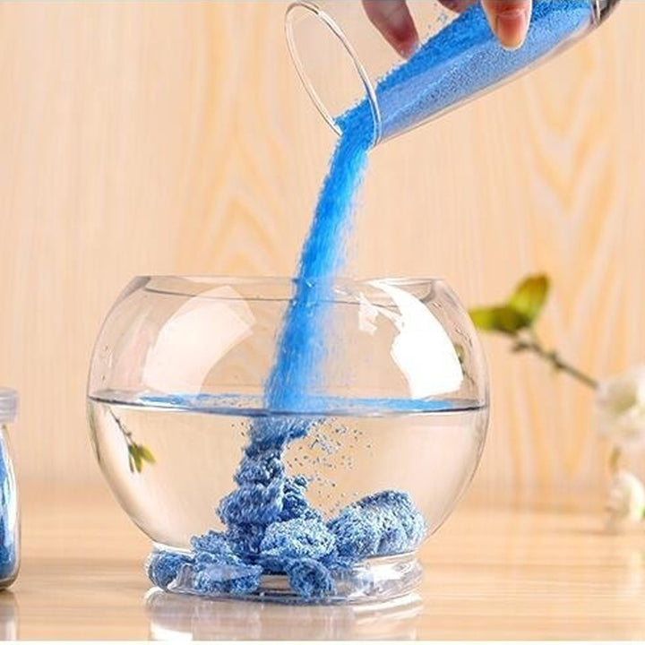 Blauw magisch zand in een glas water