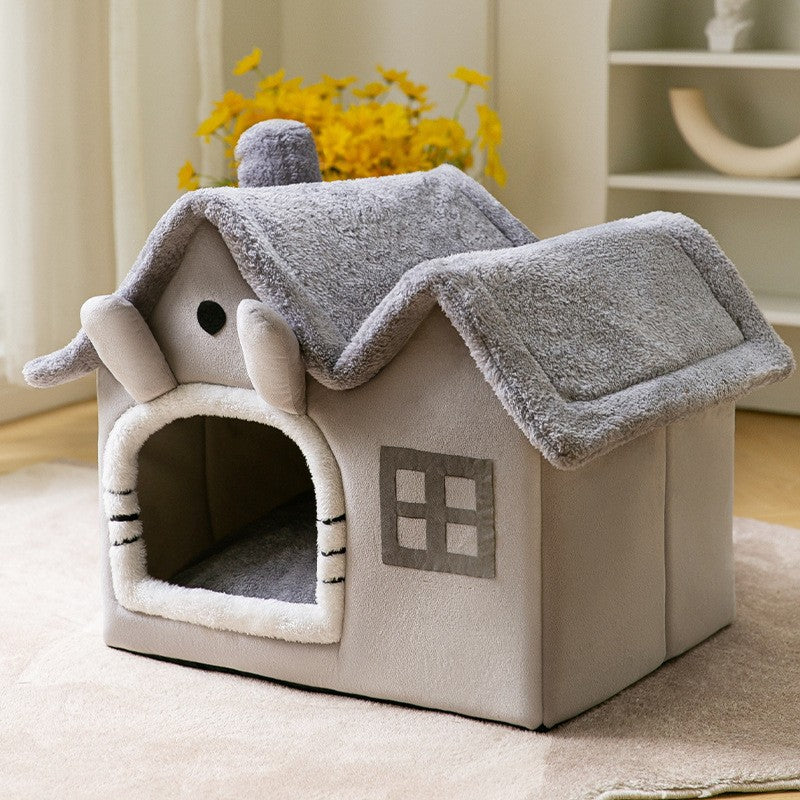 Kat kijkt uit een grijs pluche kattenhuisje