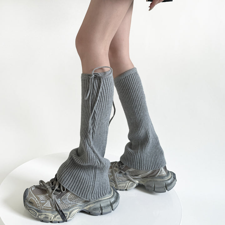 Geribde beenwarmers met strik over schoenen