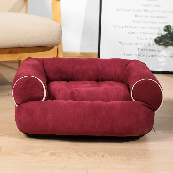 Hond ligt op een grijze pluche hondensofa