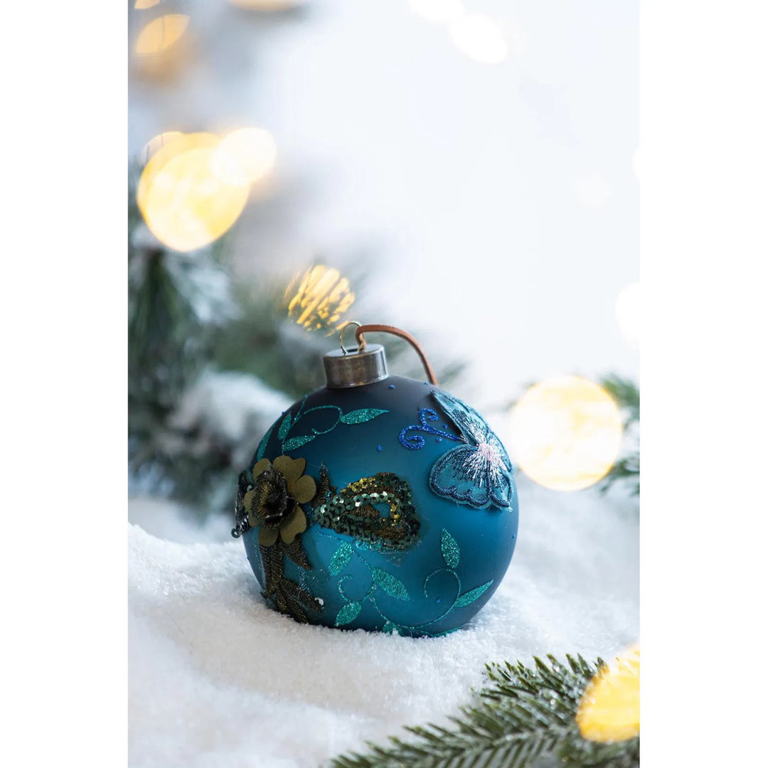 Vier petrolblauwe glazen kerstballen met glitter