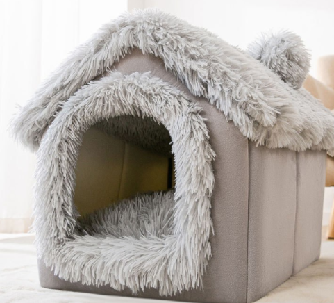 Kat kijkt uit een grijs pluche kattenhuisje