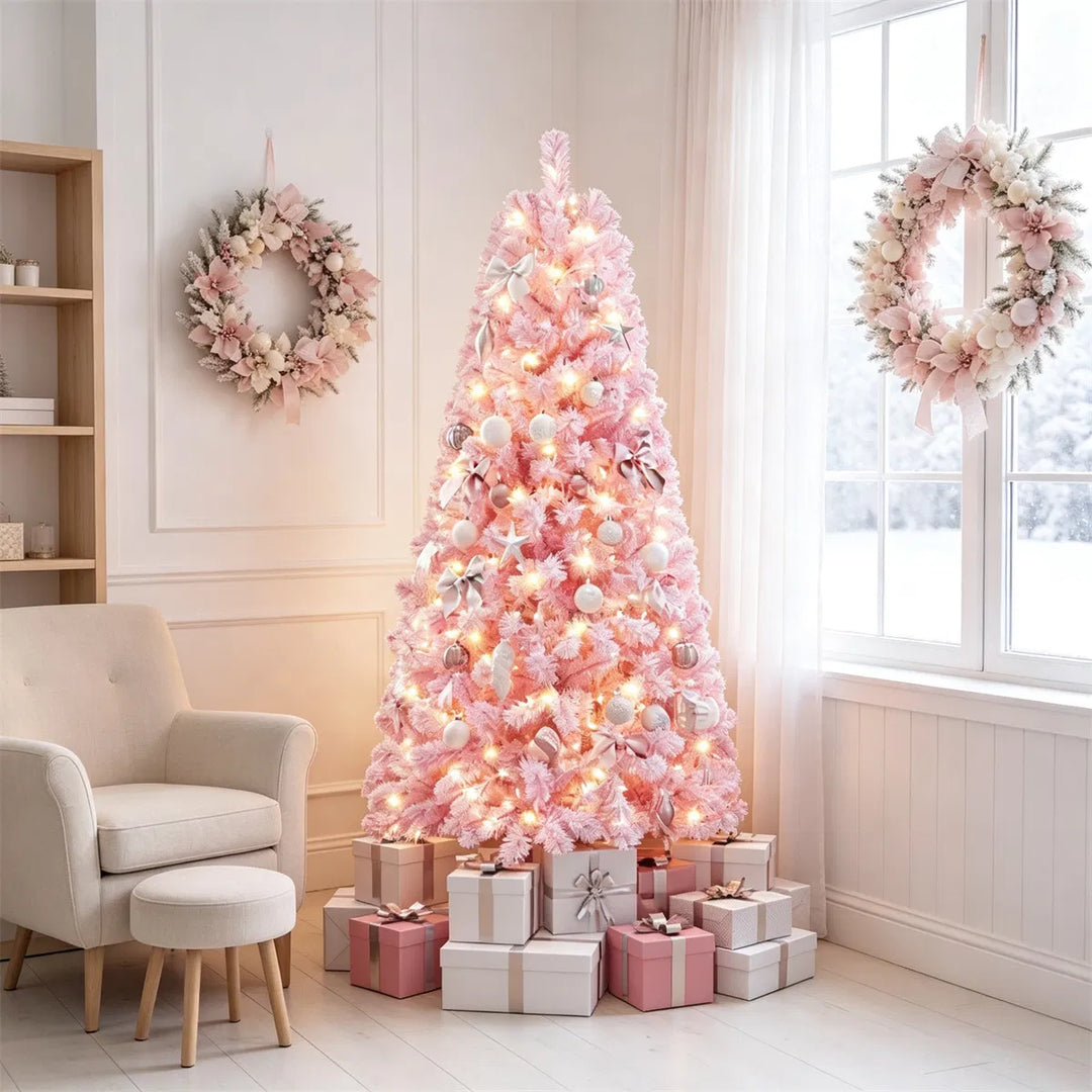 Kleine roze besneeuwde kerstboom met lichtjes