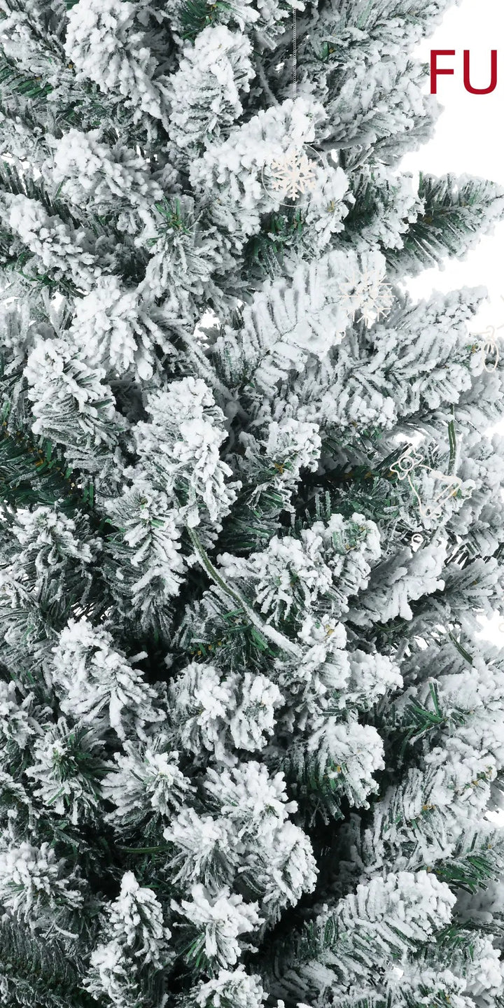 Besneeuwde smalle kerstboom met warme lichtjes