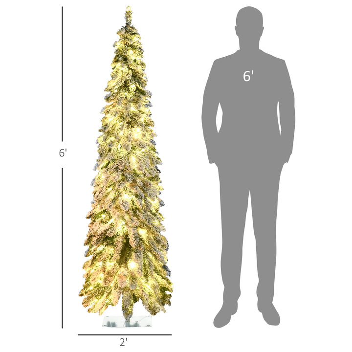 Smalle besneeuwde kerstboom met kleurlichtjes