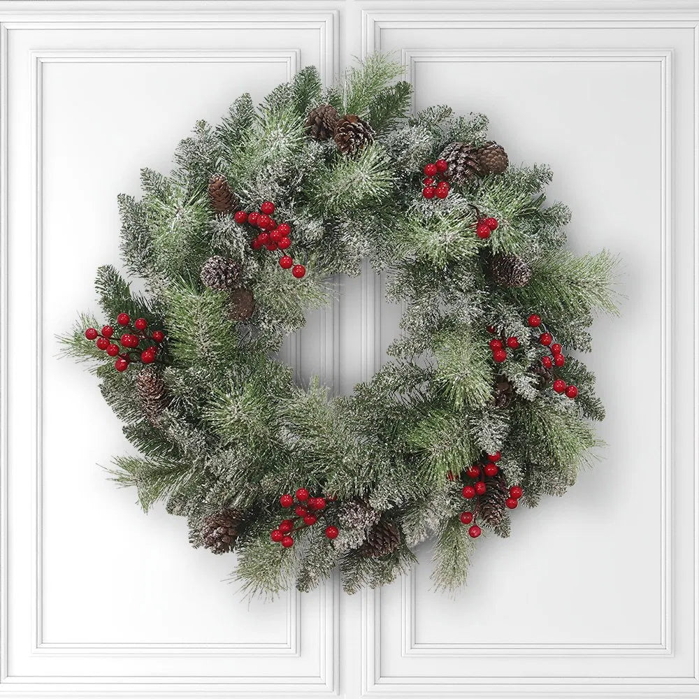 Verlichte kerstkrans met dennenappels en bessen