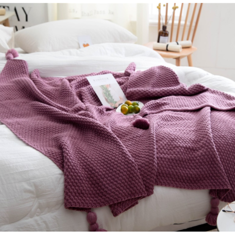 Wafelgebreide plaid met pompons voor op de bank