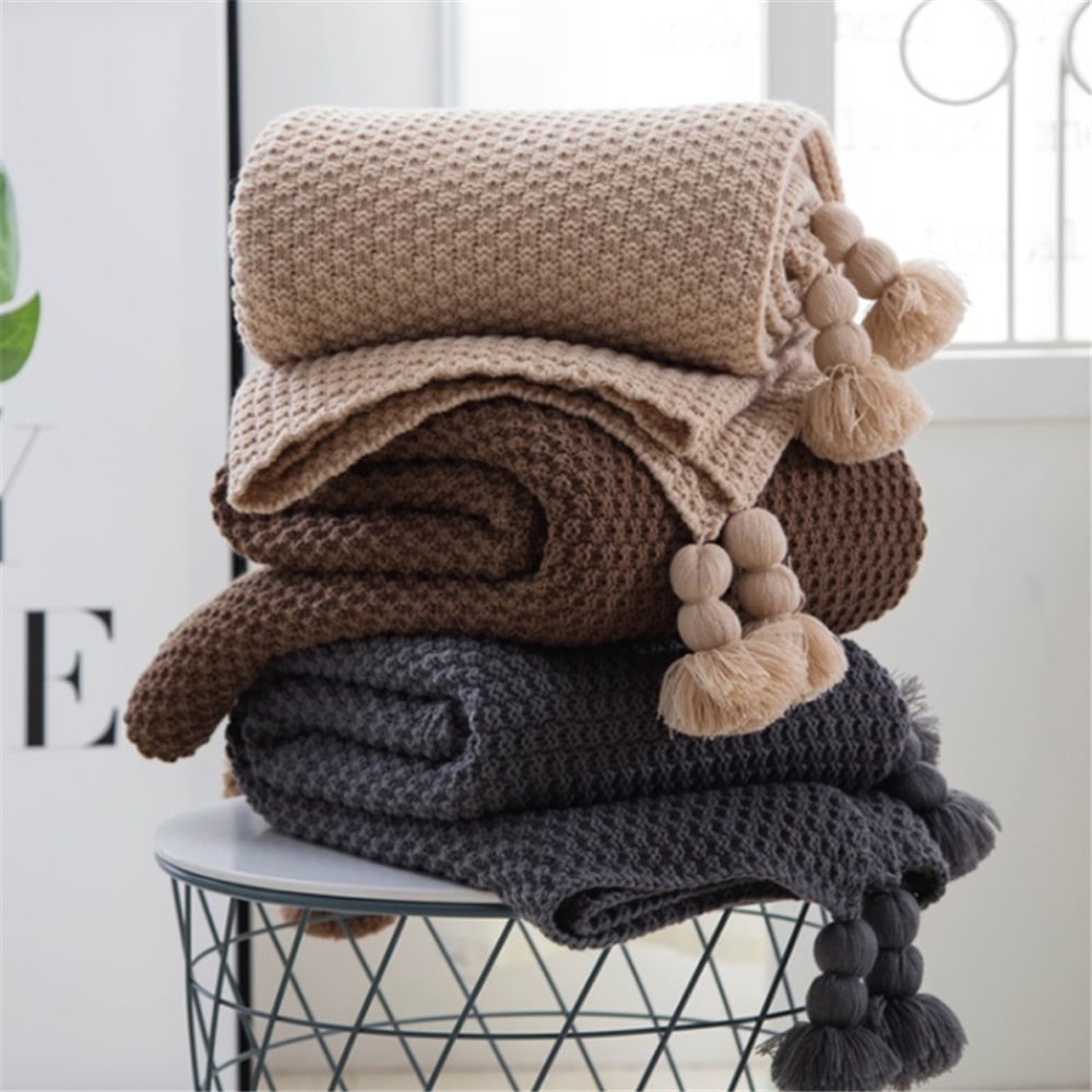 Wafelgebreide plaid met pompons voor op de bank
