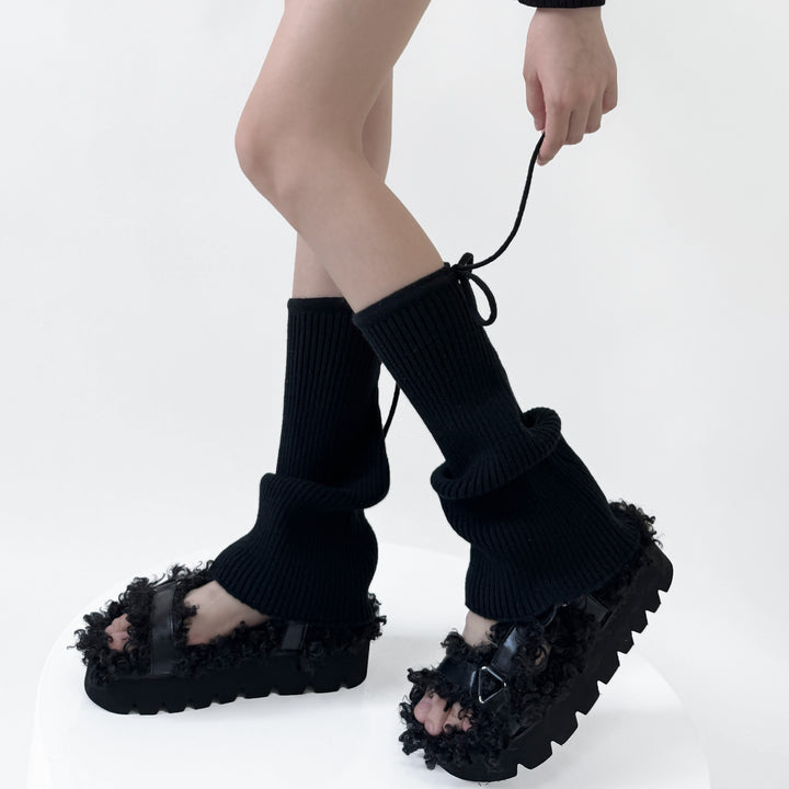 Geribde beenwarmers met strik over schoenen