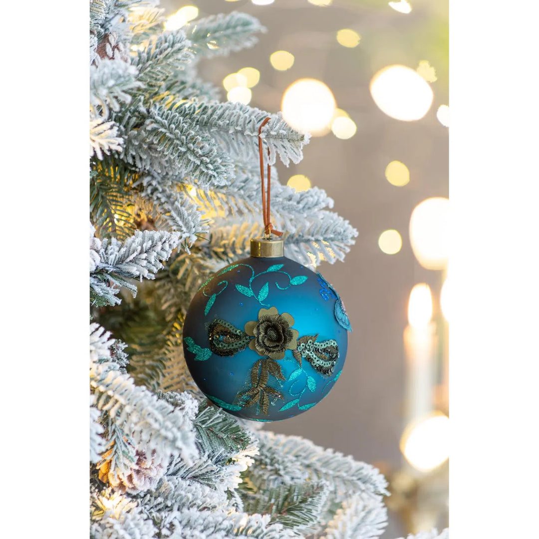 Vier petrolblauwe glazen kerstballen met glitter