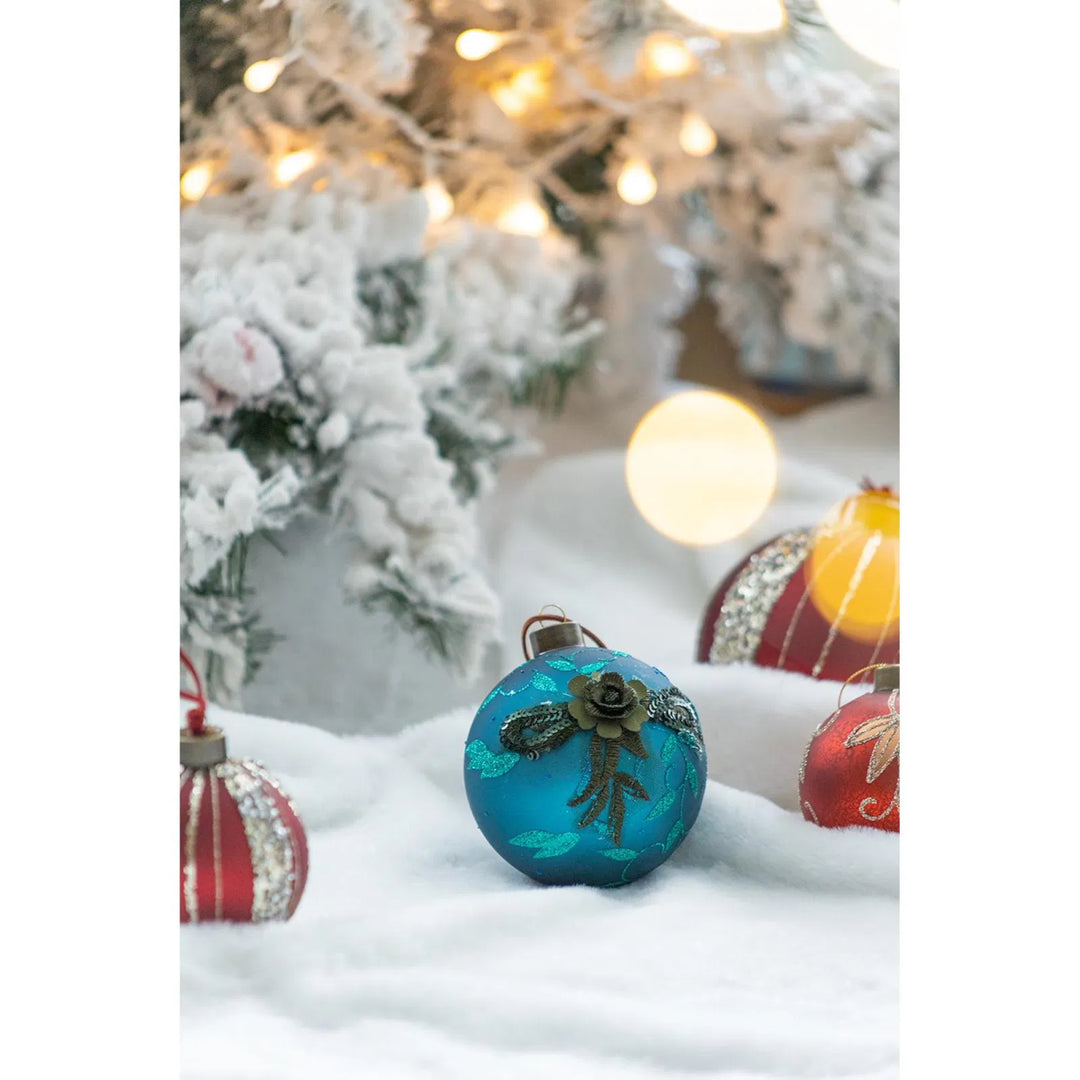 Vier petrolblauwe glazen kerstballen met glitter