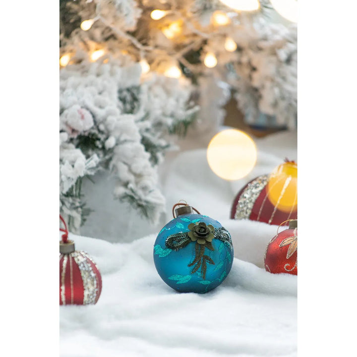 Vier petrolblauwe glazen kerstballen met glitter