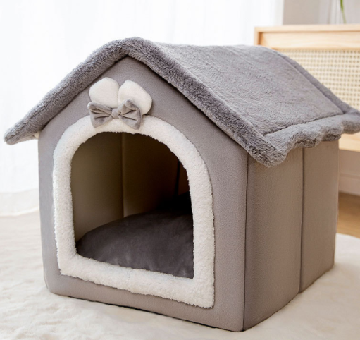 Kat kijkt uit een grijs pluche kattenhuisje